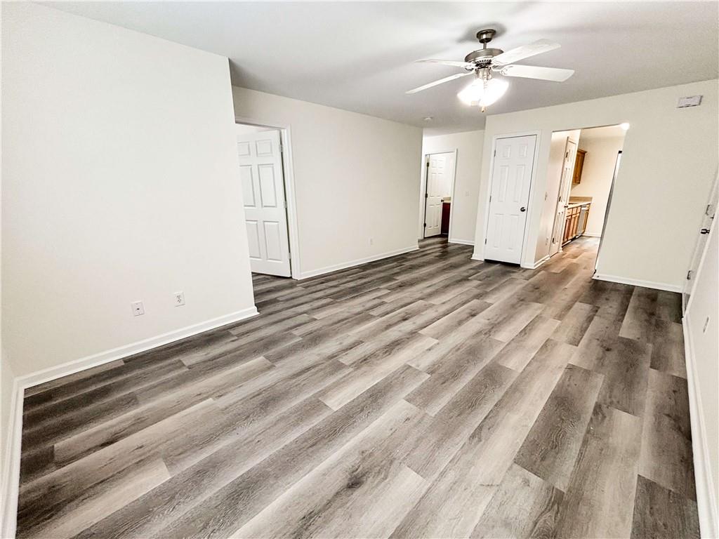 1400 Stonehaven Circle, Unit 1402 Cartersville, GA 30121 - Photo 5 of 23 a view of a livingroom with wooden floor and a ceiling fan