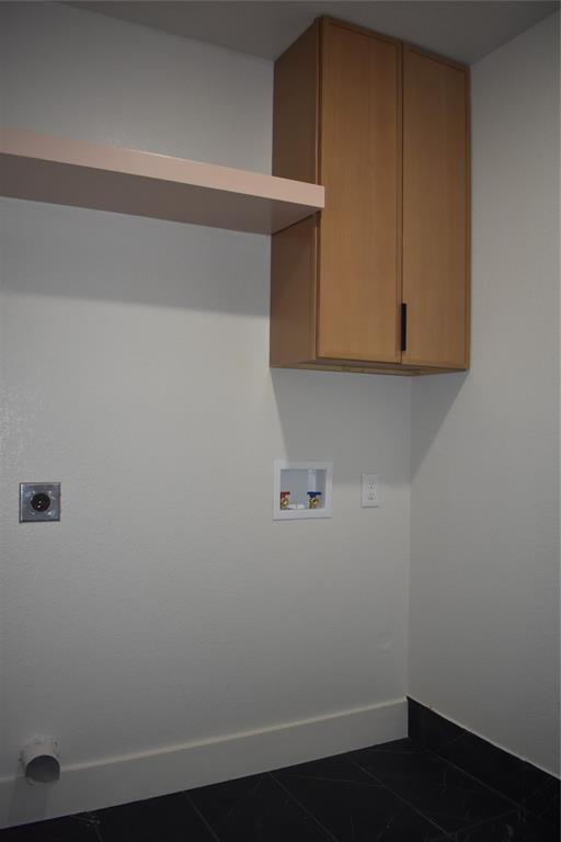2908 Washington Street Commerce, TX 75428 - Photo 35 of 40 Dedicated laundry area featuring a wall-mounted cabinet, a floating shelf, and dark-toned flooring