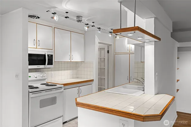 a kitchen with stainless steel appliances kitchen island a sink stove and refrigerator