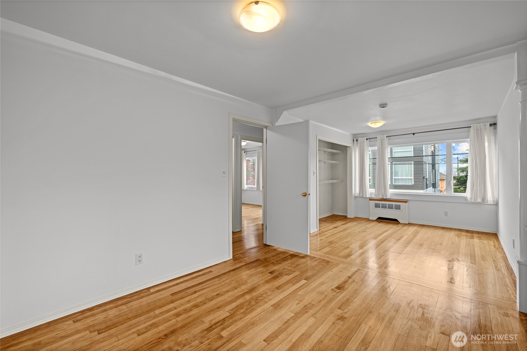 634 13th Avenue East, Unit 17 Seattle, WA 98102 - Photo 18 of 39 a view of an empty room with wooden floor and a window