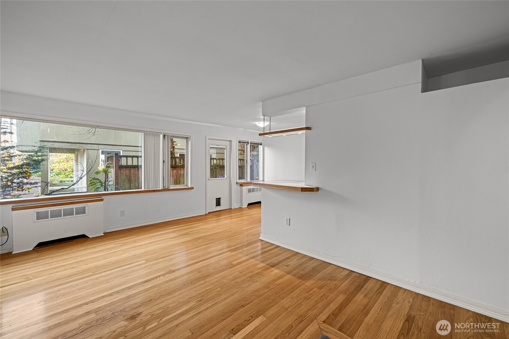 634 13th Avenue East, Unit 17 Seattle, WA 98102 - Photo 19 of 39 a view of an empty room with wooden floor and a window