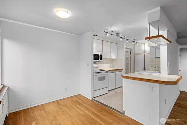 a kitchen with granite countertop white cabinets and white appliances