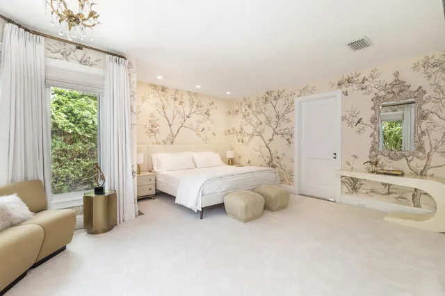 a spacious bedroom with furniture and a large window