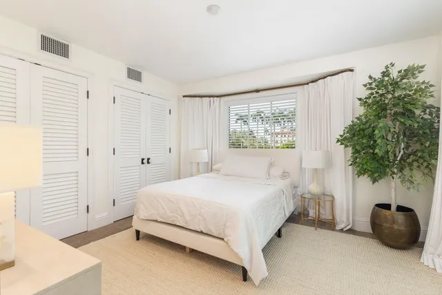 a bedroom with a bed and a potted plant