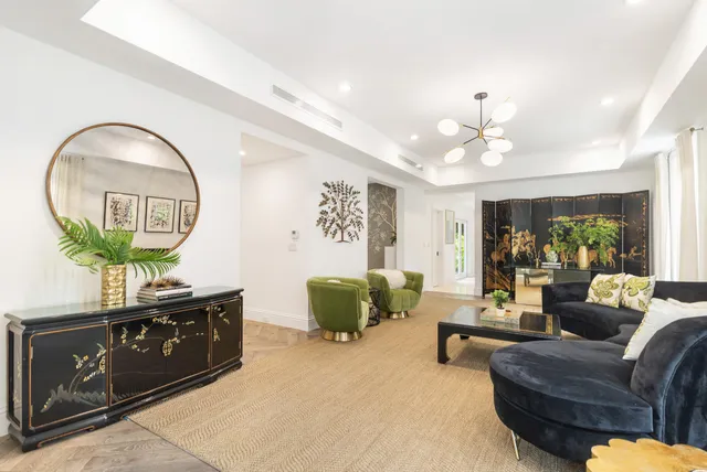 a living room with furniture a potted plant and a chandelier
