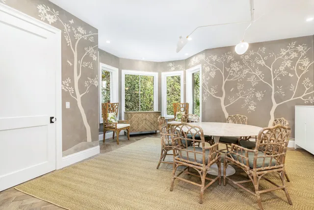 a dining room with furniture and large windows