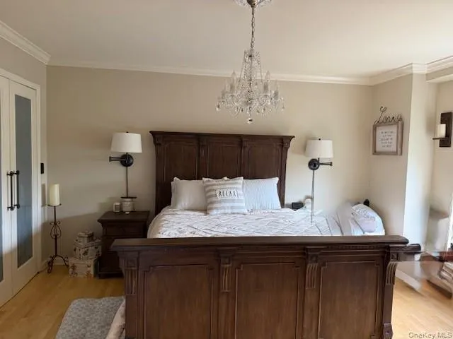 a bedroom with a bed and a chandelier
