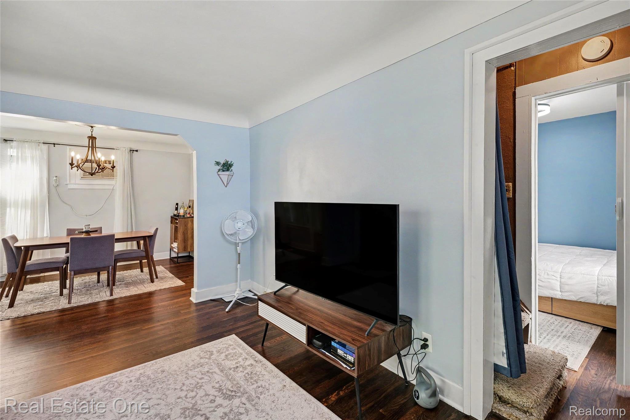 2073 Roslyn Road Grosse Pointe, MI 48236 - Photo 7 of 30 Hardwood-style flooring throughout, with an arched entryway leading to a separate dining area featuring a chandelier
