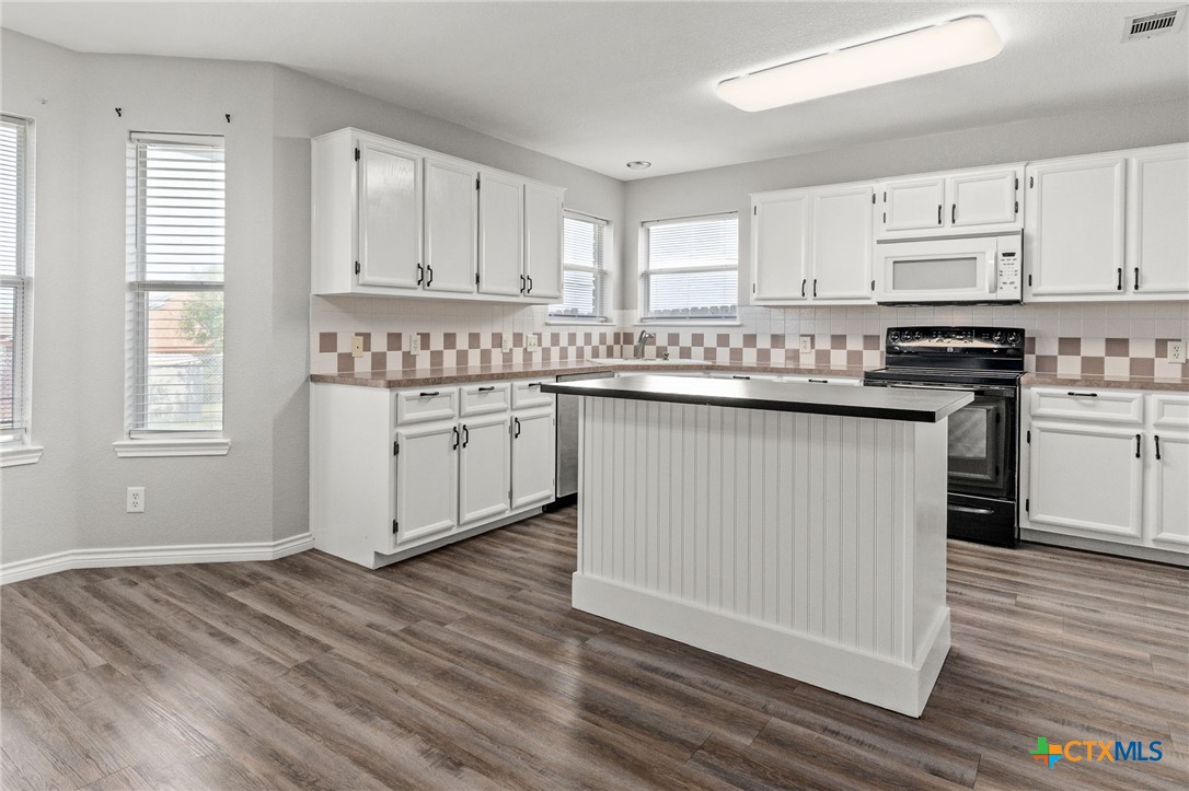 4305 Maggie Drive Killeen, TX 76549 - Photo 4 of 14 a kitchen with stainless steel appliances granite countertop a stove a sink and white cabinets