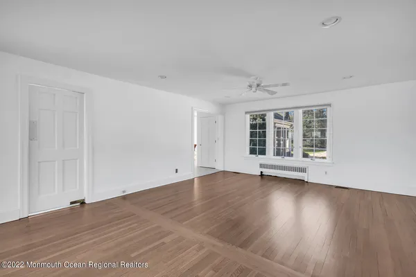 a view of an empty room with a fireplace and a window