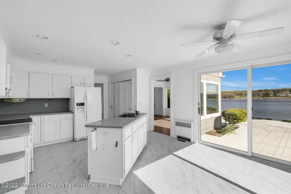 a large white kitchen with a large window