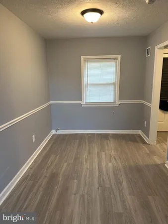 a view of a room with wooden floor and window