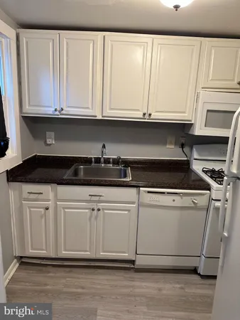 a kitchen with stainless steel appliances granite countertop a sink a stove and cabinets