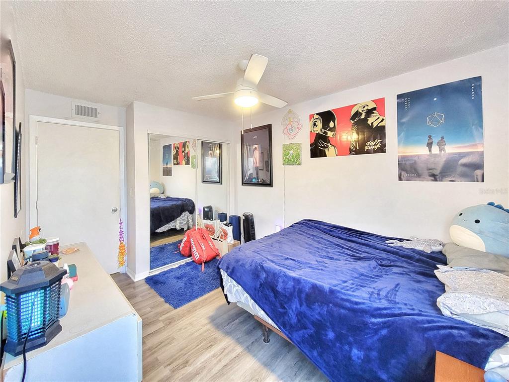 2601 Southwest Archer Road, Unit H330 Gainesville, FL 32608 - Photo 18 of 28 a bedroom with a bed and wooden floor