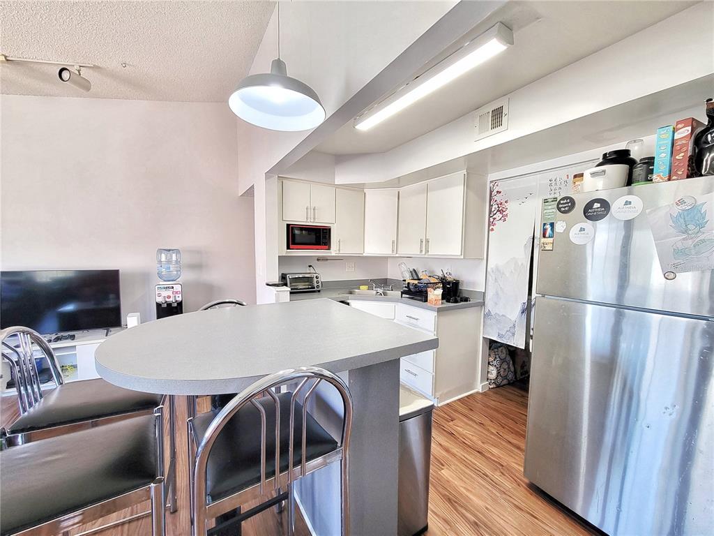 2601 Southwest Archer Road, Unit H330 Gainesville, FL 32608 - Photo 7 of 28 a kitchen with stainless steel appliances a refrigerator and a table