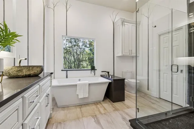 a bathroom with a granite countertop sink toilet and mirror