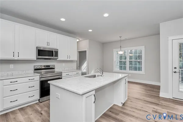 a view of an empty room with wooden floor fireplace and a window