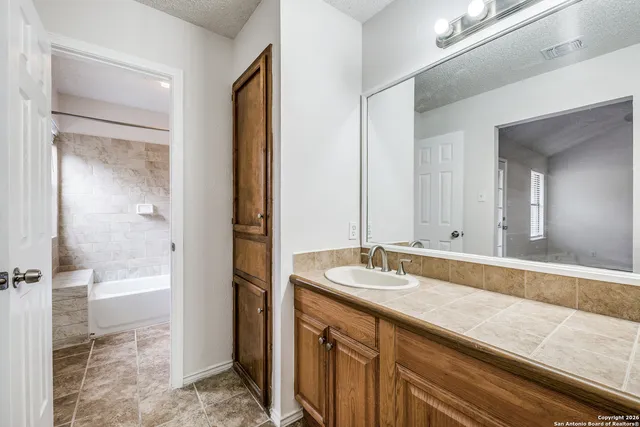 a bathroom with a granite countertop sink and a mirror