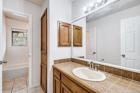 a bathroom with a granite countertop sink and a mirror