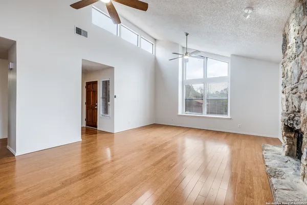an empty room with wooden floor and windows