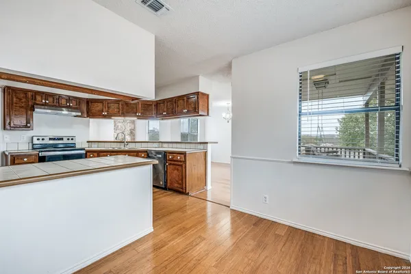 a kitchen with stainless steel appliances granite countertop a stove a sink and a refrigerator