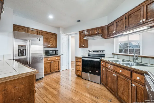 a kitchen with stainless steel appliances granite countertop a refrigerator and a stove top oven