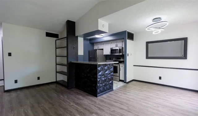 a view of a kitchen with cabinets and wooden floor