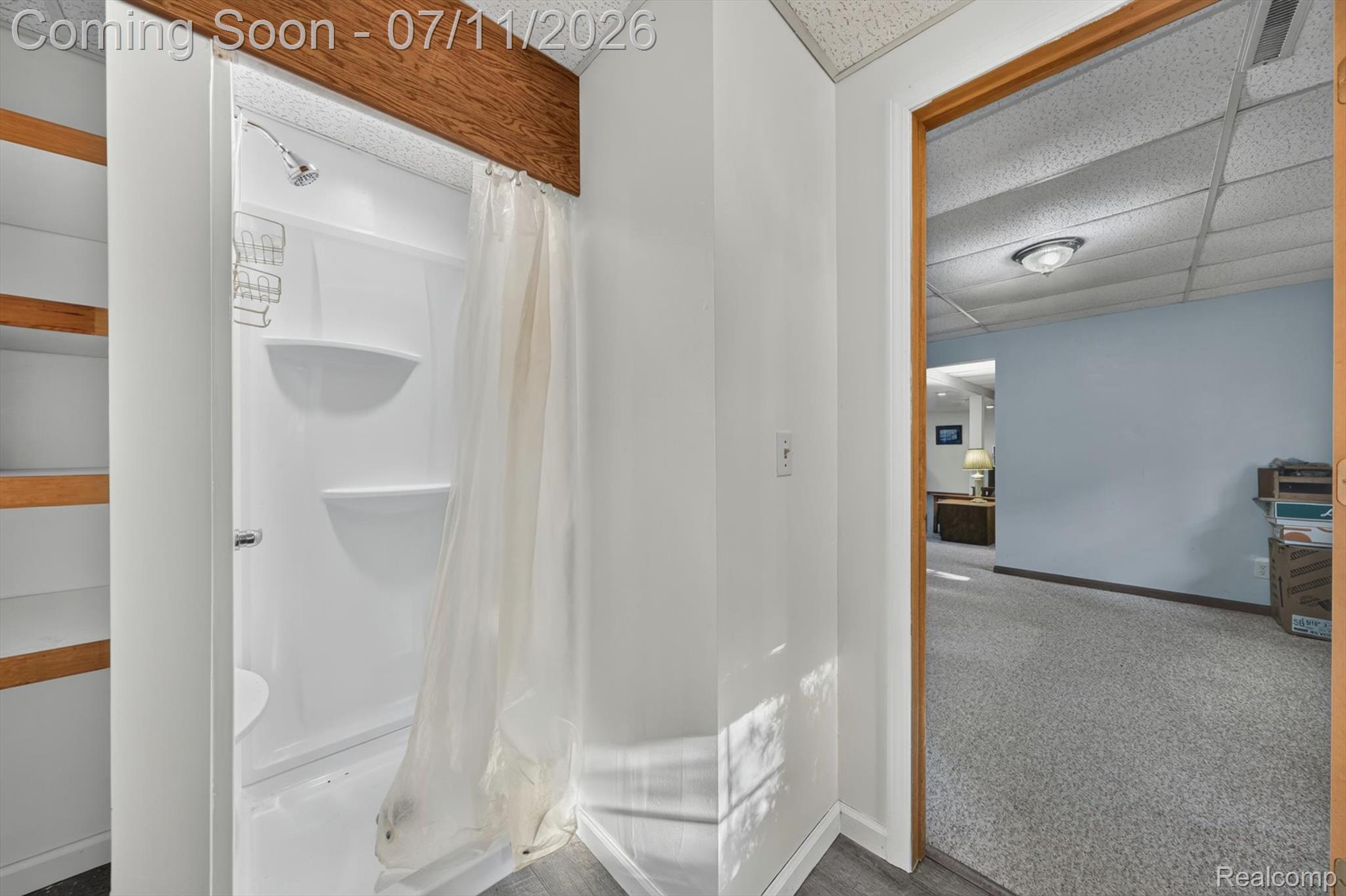 4430 North Center Road Flint, MI 48506 - Photo 30 of 49 White fiberglass shower stall with built-in shelving, chrome showerhead, and exposed wood beam