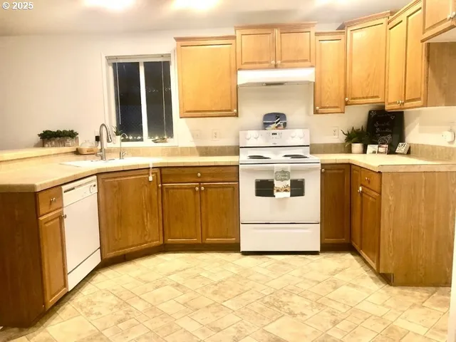 a kitchen with a stove a sink and white cabinets