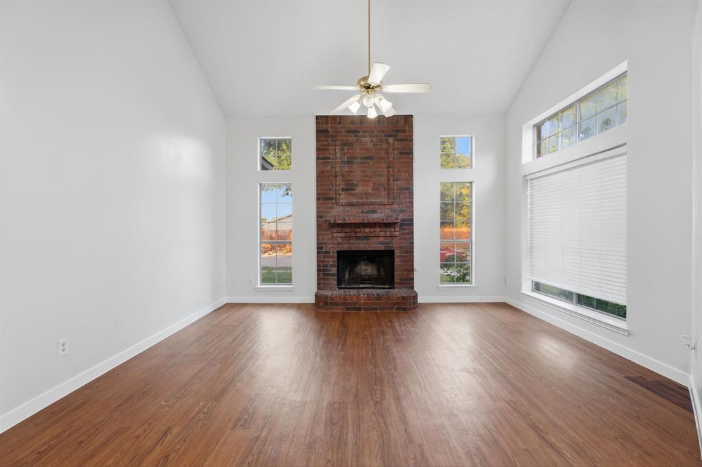 3721 Smartt Street Rowlett, TX 75088 - Photo 4 of 27 a view of a livingroom with wooden floor a fireplace and window