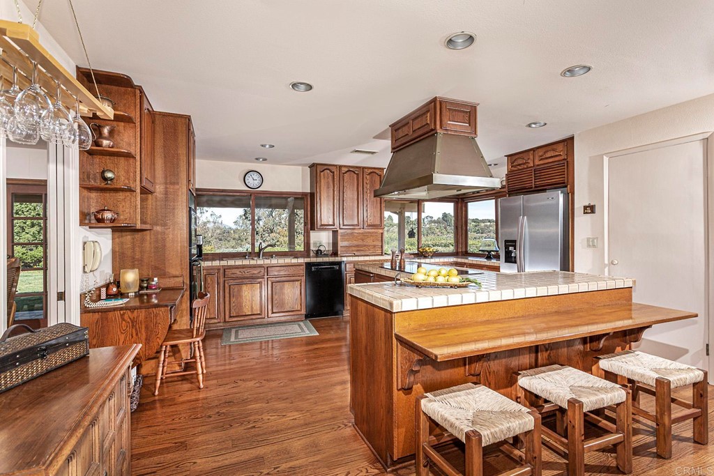 16854 Los Morros Rancho Santa Fe, CA 92067 - Photo 11 of 40 a view of a kitchen with stainless steel appliances granite countertop a stove and a dining table view