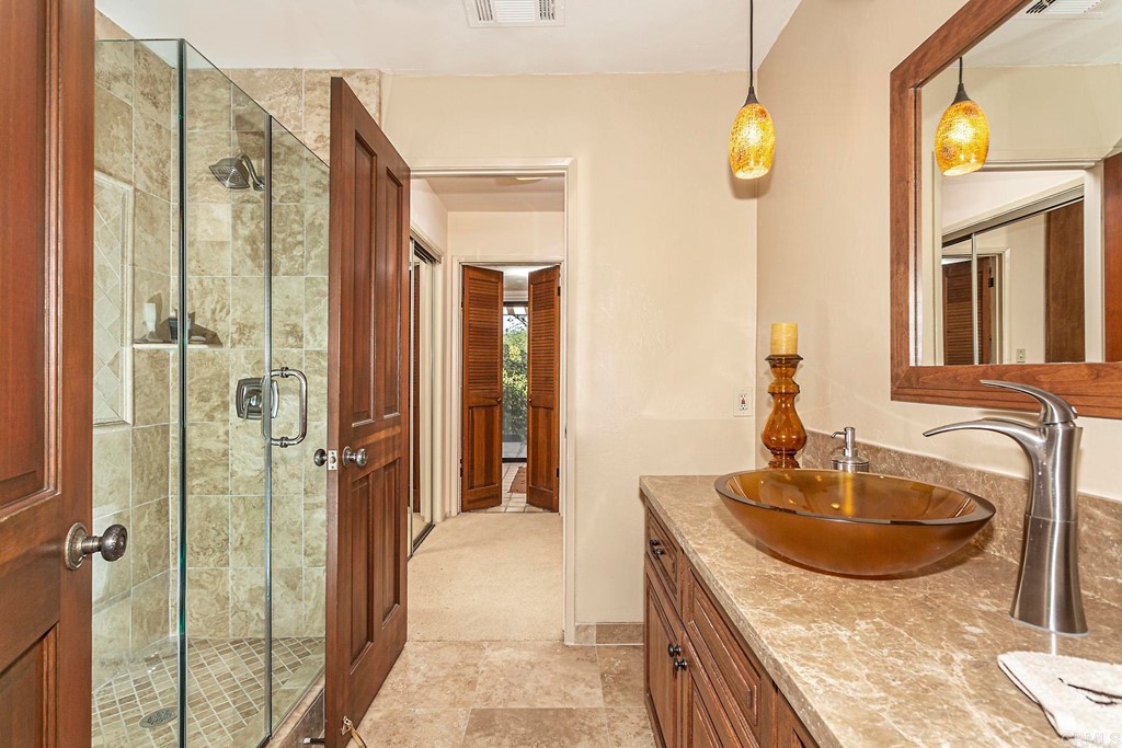 16854 Los Morros Rancho Santa Fe, CA 92067 - Photo 21 of 40 a bathroom with a granite countertop sink a mirror and shower