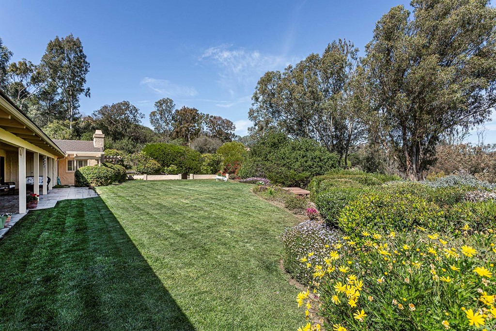 16854 Los Morros Rancho Santa Fe, CA 92067 - Photo 32 of 40 a view of a garden with a building in the background