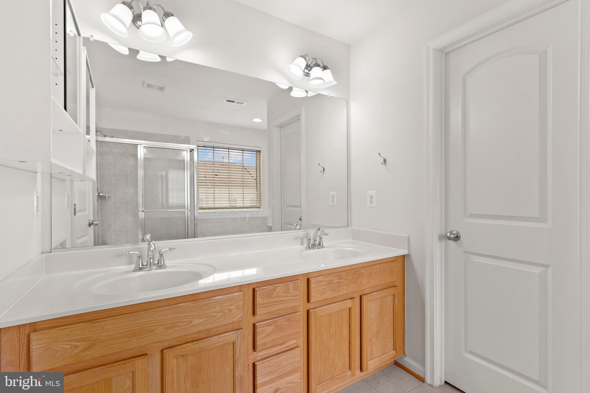 22667 Flowing Spring Square Brambleton, VA 20148 - Photo 26 of 39 a bathroom with a sink vanity granite and a mirror