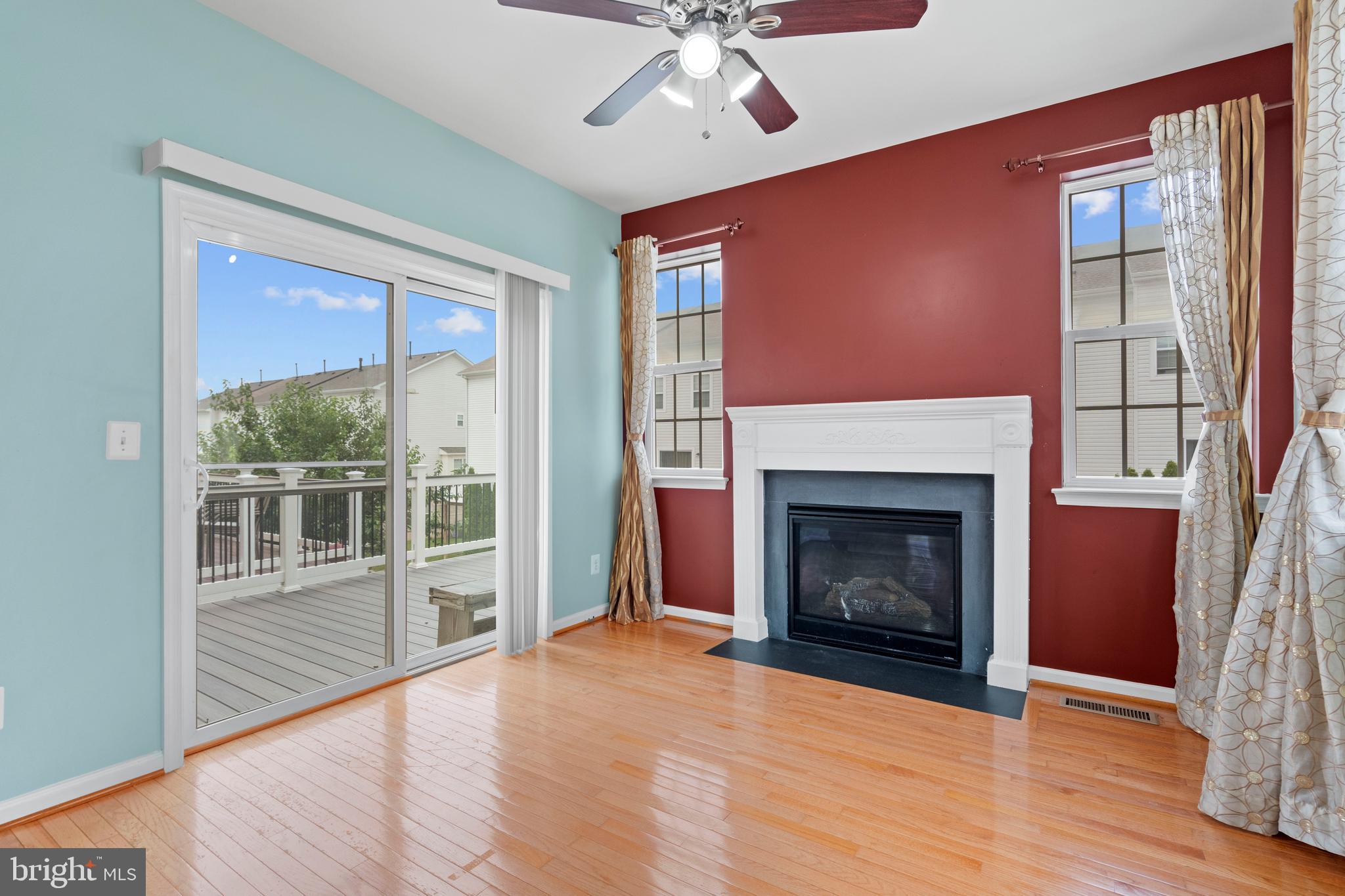 22667 Flowing Spring Square Brambleton, VA 20148 - Photo 9 of 39 a view of an empty room with wooden floor fireplace and a window
