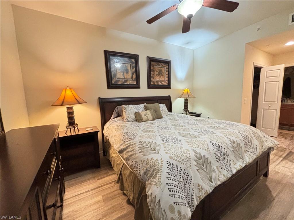 10341 Heritage Bay Boulevard, Unit 1922 Naples, FL 34120 - Photo 11 of 36 a bedroom with a bed and a lamp