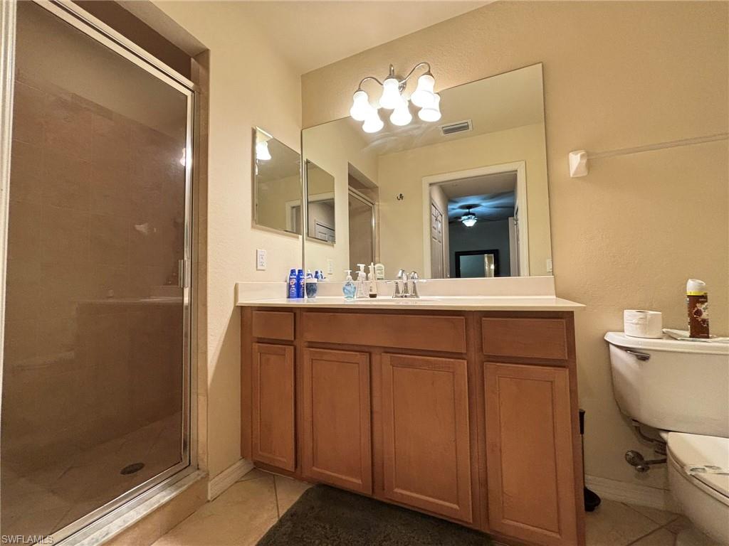 10341 Heritage Bay Boulevard, Unit 1922 Naples, FL 34120 - Photo 13 of 36 a bathroom with a double vanity sink mirror and toilet