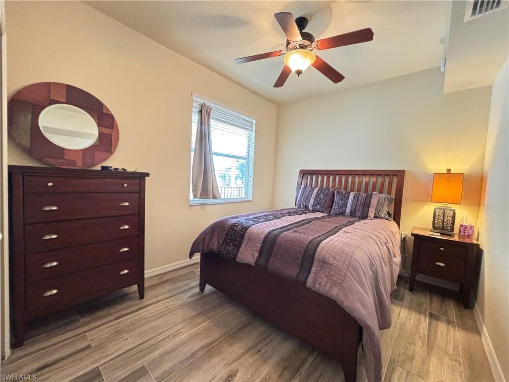 10341 Heritage Bay Boulevard, Unit 1922 Naples, FL 34120 - Photo 14 of 36 a bedroom with a bed and a chandelier