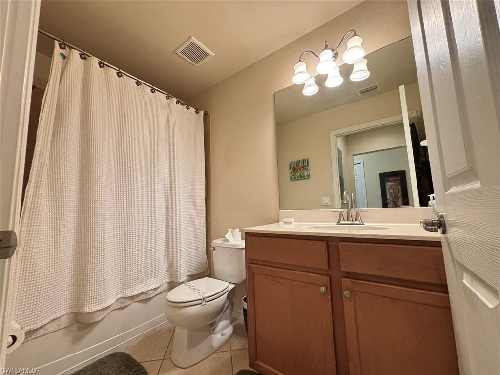 10341 Heritage Bay Boulevard, Unit 1922 Naples, FL 34120 - Photo 16 of 36 a bathroom with a toilet a sink and a mirror