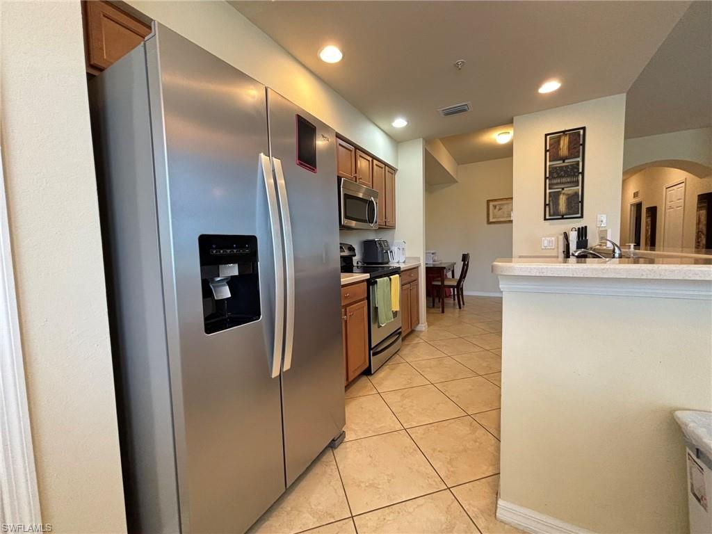 10341 Heritage Bay Boulevard, Unit 1922 Naples, FL 34120 - Photo 6 of 36 a kitchen with stainless steel appliances a refrigerator and a stove