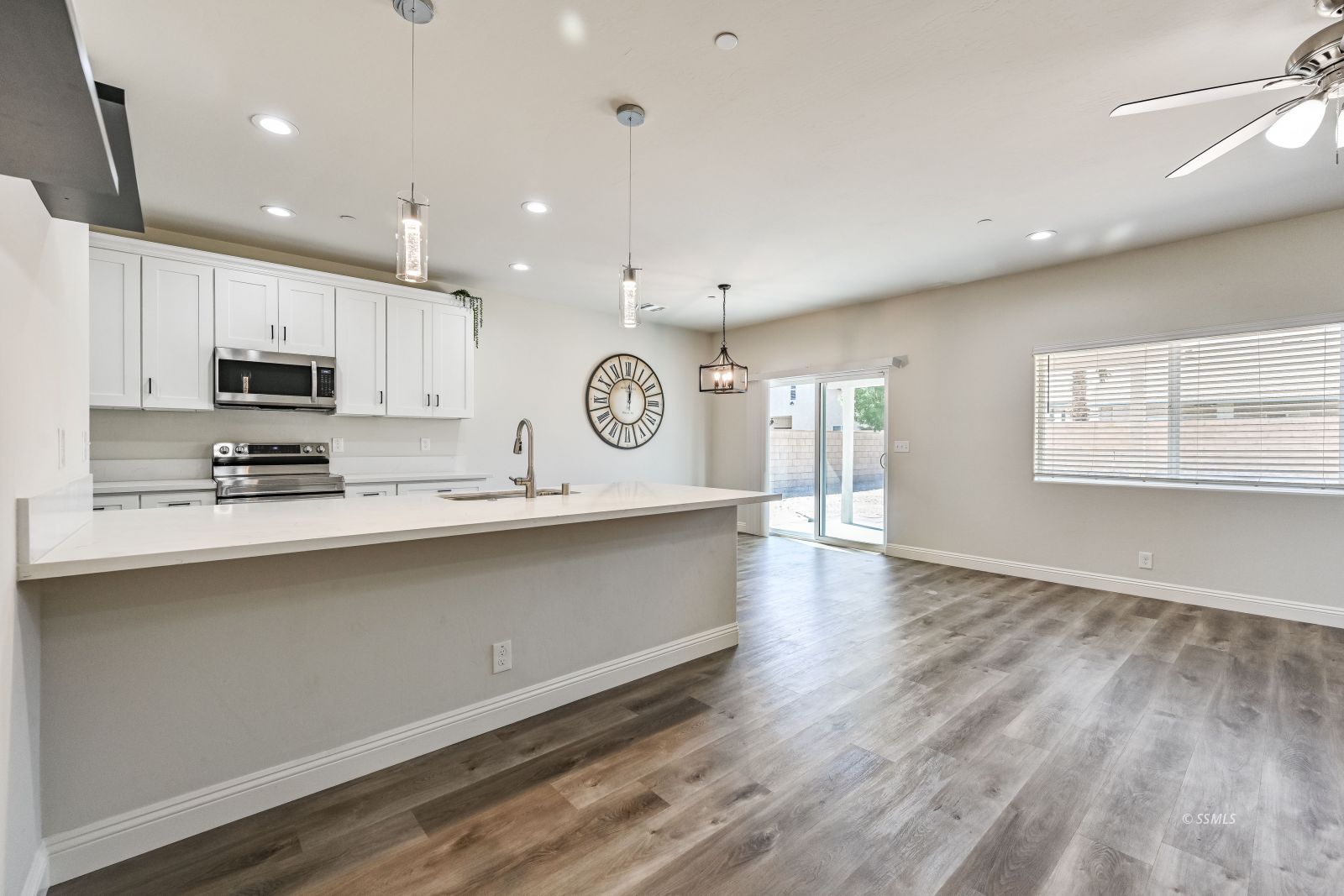 1031 West Church Avenue Ridgecrest, CA 93555 - Photo 5 of 49 a large kitchen with stainless steel appliances granite countertop a stove a sink a refrigerator white cabinets and wooden floor