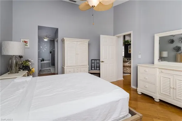 a spacious bedroom with a bed and a dresser