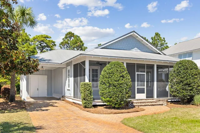 a view of a house with potted plants and a large tree