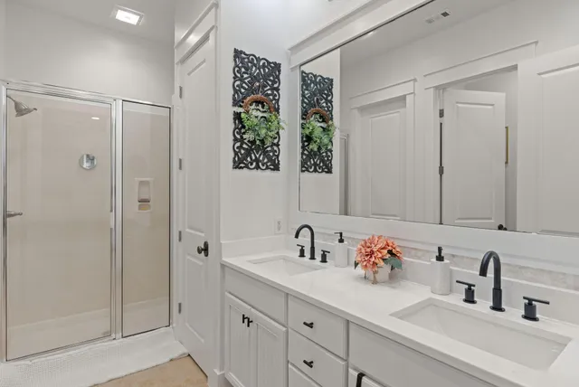 a bathroom with a shower sink vanity and mirror
