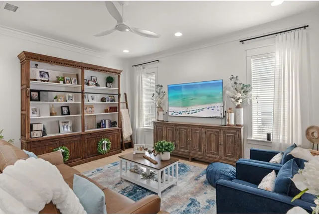 a living room with furniture a bookshelf and a window