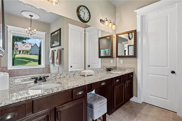 a bathroom with a granite countertop sink and a large mirror