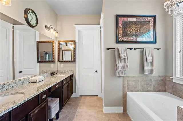 a bathroom with a granite countertop tub sink and a mirror