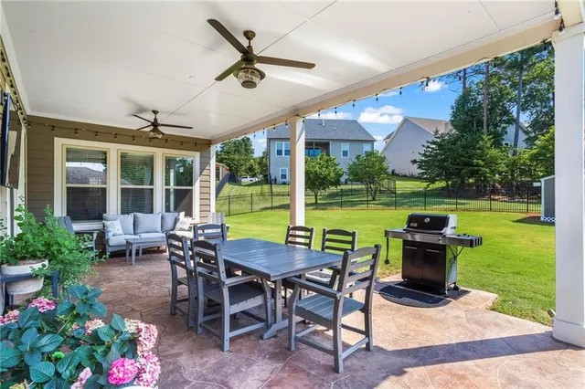 a view of a patio with table and chairs potted plants and floor to ceiling window