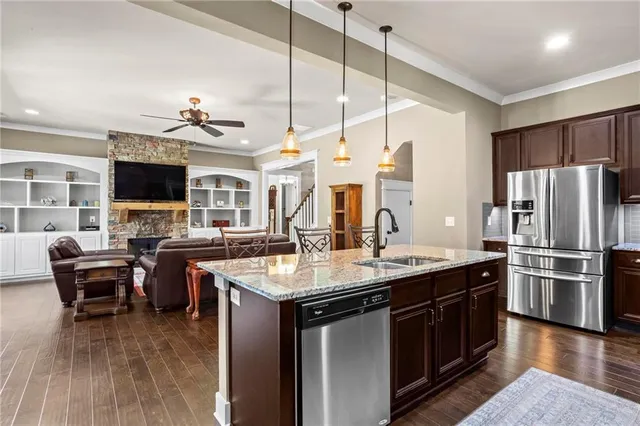 a kitchen with a sink appliances and wooden floor