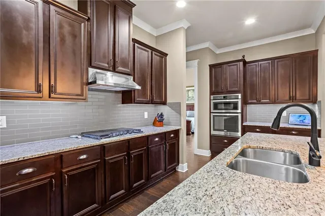 a kitchen with stainless steel appliances granite countertop a sink stove and refrigerator
